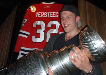 Kris Versteeg poses for a photo in front of a framed autographed jersey with the Stanley Cup at Boss Hogg's in Lethbridge, AB.
