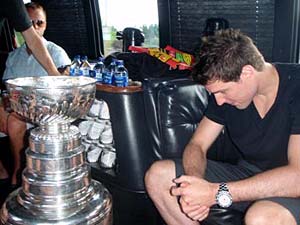 Patrick Sharp looking over the names of past championships engraved on the Stanley Cup