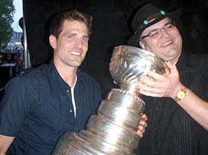 Patrick Sharp and John Popper of the band Blues Traveler sharing a moment with the Cup