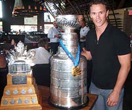 Jonthan Toews shows off the Conn Smythe trophy, the Stanley Cup and his Olympic Gold Medal