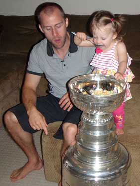 Rich Peverley looks on as his daughter Isabella enjoys some cereal from the bowl of the Stanley Cup.