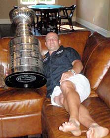 Marc Savard relaxes on his couch with the Stanley Cup.