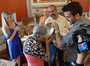 Patrice Bergeron and his father helping a family member enjoy a drink from the bowl of the Stanley Cup while girlfriend Stephanie looks on.