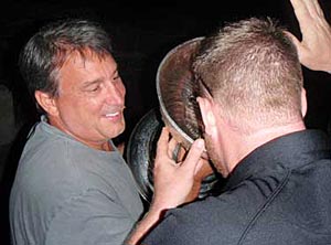 Cam Neely helping a friend enjoy a drink from the bowl of the Stanley Cup.