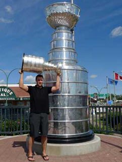 Johnny Boychuk and the Stanley Cup posing for a photo beside a giant replica Stanley Cup in Edmonton, AB.