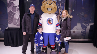 Family posing with mascot Slapshot