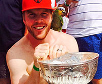 A Hawk, a parrot and the Stanley Cup pose for a photo.