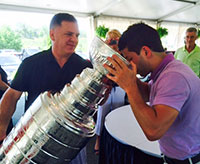 At Willow Valley Golf Club, Mark Bernard pours a drink for a friend from hockey's most coveted trophy