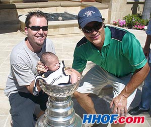 The Anaheim Ducks' Teemu Selanne with a neighbour's infant and the Stanley Cup.