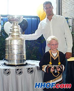 The Anaheim Ducks' Ryan Getzlaf and the Stanley Cup pose with ten-year-old charity fundraiser Ryan Smith