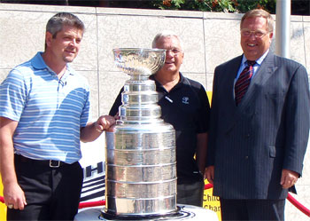 The Detroit Red Wings' Todd McLellan joins a representitive from KidSport and the Mayor of Saskatoon Don Atchison for a photo with the Stanley Cup.