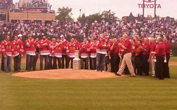 At interleague baseball between the Chicago White Sox and Chicago Cubs Jonathan Toews hands the ceremonial first pitch baseball to president of the Chicago Blackhawks and long-time marketing executive of the Cubs John McDonough.
