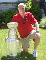 President of the Hawks John McDonough shares a moment with the Stanley Cup