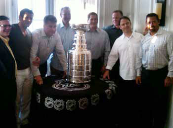Members of the Chicago Blackhawks scouting staff sharing a moment with the Stanley Cup during NHL Draft weekend.
