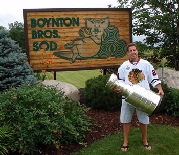 Nick Boynton poses for a photo with the Stanley Cup in front of the Boynton Bros. Sod sign in Nobleton, ON.