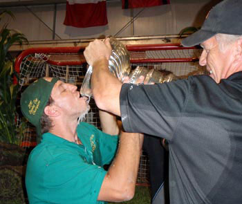 Nick Boynton celebrating with a drink from the Stanley Cup during a pig roast at the family sod farm.