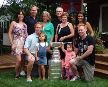 Brian Campbell and family pose for photos with the Stanley Cup in their backyard.