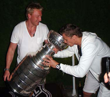 Marian Hossa helping teammate Tomas Kopecky drink from the Stanley Cup at party hosted by the Hossa family.
