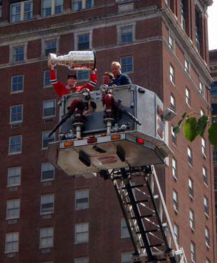 Patrick Kane and the Stanley Cup hoisted above the city of of Buffalo in the bucket of the Buffalo Fire Department.