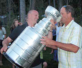 Doug Houda helping a friend enjoy a drink from the Stanley Cup