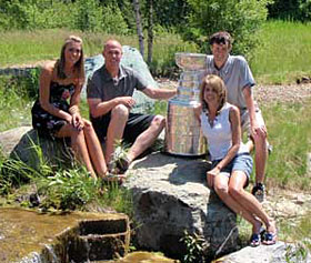 Bruins assistant coach Doug Houda and family posing for a photo with Lord Stanley at their home in Whitefish, MT.