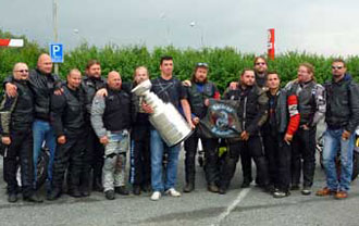Tomas Kaberle and the Stanley Cup posing for a photo with some motorcycle enthusiasts.