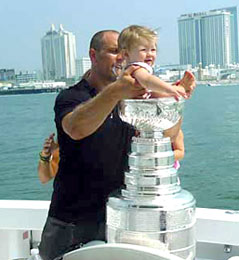 Dennis Seidenberg helping his daughter Noah Grace take a seat in the bowl of the Stanley Cup.