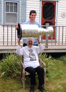 Adam McQuaid helping his grandmother hoist the Stanley Cup during a visit at her home in Cornwall, PEI.