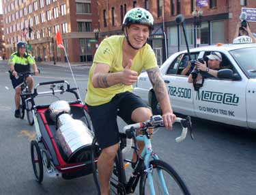 Andrew Ference biking around Boston with Lord Stanley in a carrier.