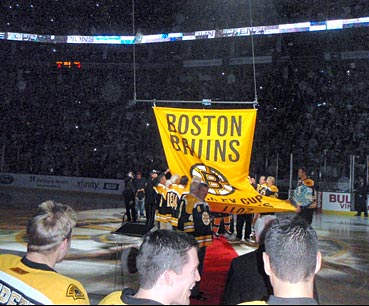 Members of the Bruins past and present prepare the 2011 Stanley Cup championship banner to be raised to the rafters of the TD Garden.