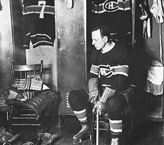 Aurele Joliat sits beside the empty seat where his good friend and teammate Howie Morenz used to sit before his passing on March 8, 1937.