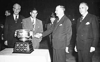 Lester Patrick (left) and Clarence Campbell (right) are on hand as Elmer Lach receives the trophy named after Art Ross (2nd from right) in 1948.