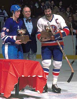 Bill Torrey makes a presentation to Islanders captain Clark Gillies and a member of Telsa Pardubice following an exhibition game on January 4, 1978.