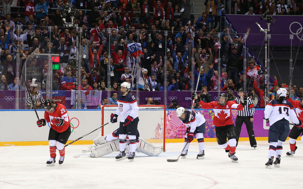 Marie-Philip Poulin and Canada celebrate after her tying goal with less than a minute left in regulation. She would also go on to score in overtime to capture gold at the 2014 Olympic Winter Games. (Photo by Andre Ringuette/HHOF-IIHF Images).